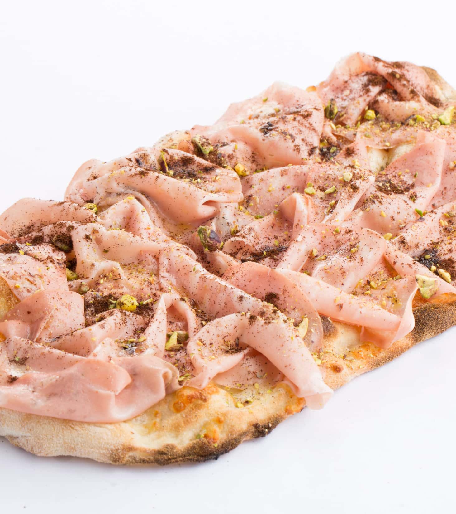 Photo of a Pinsa topped with pistachios and mortadella.