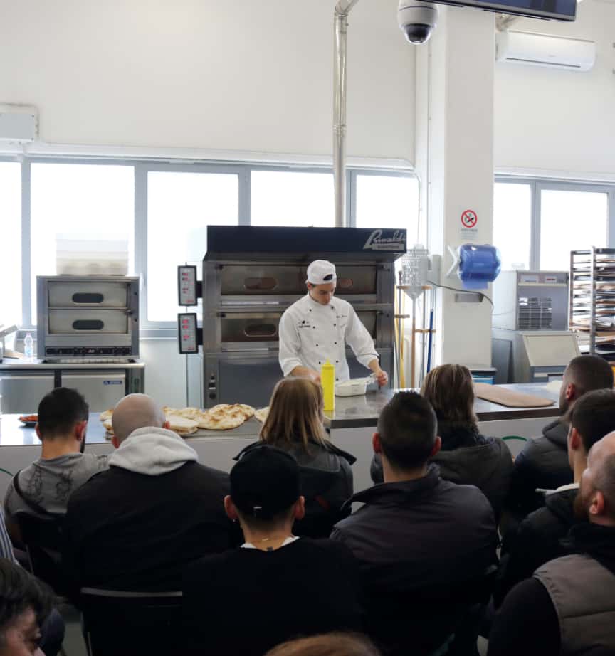 Photo of a Pinsa Romana class with a cook kneading in front of an audience