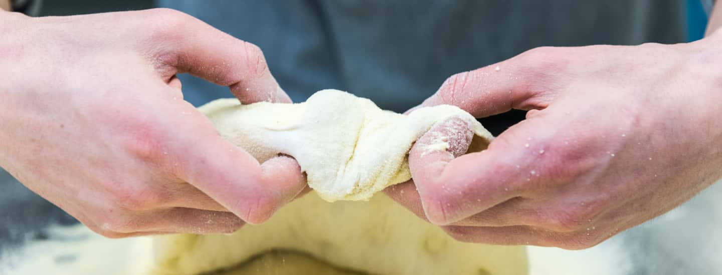 Detail of a cook's hands with dough