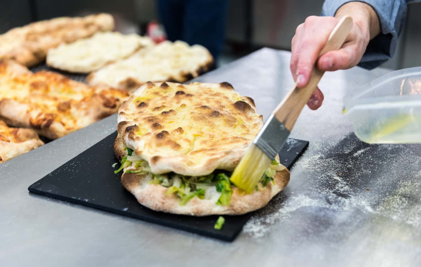 Photo of a pinsa stuffed with vegetables on a plate